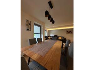 Un comedor con mesa y sillas de madera. en Holiday apartment Robin, en Waidring