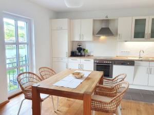 Hallenbach with Moselle view في زيل ان دير موسل: مطبخ مع طاولة وكراسي خشبية