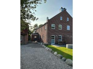 a brick house with a gravel driveway in front of it at The Linnebargs, House 1 in Bisdorf