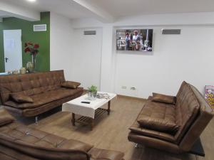 a living room with two leather couches and a table at El Albergue del Montero in Mondoñedo