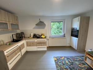 LangenhennersdorfHoliday home at the rock labyrinth的厨房配有白色橱柜和窗户。