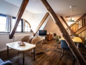 Holiday apartment Gutshof Bastorf في Bastorf: غرفة معيشة بها طاولة وكراسي