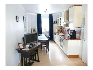 a kitchen with a desk with a television and a table at 4-star holiday apartments Weber in Winningen