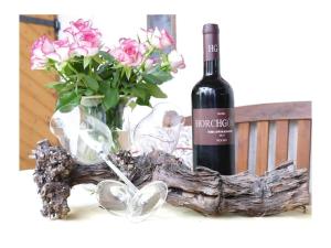 a bottle of wine sitting next to a vase of flowers at 4-star holiday apartments Weber in Winningen