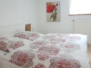 Bett mit rosa und weißer Bettwäsche und Kissen in der Unterkunft holiday apartment in Backenreute
