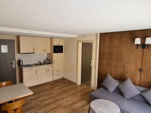 ein Wohnzimmer mit Couch und Küche in der Unterkunft Holiday apartment I in Chalet Bodenwald in Grindelwald + 14 Fotos
