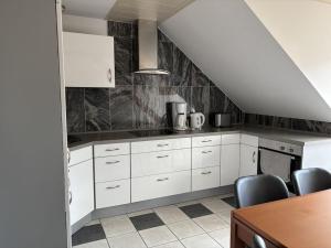 a kitchen with white cabinets and a staircase at Holiday apartment Ina in Sankt Aldegund