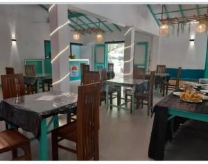 a dining room with tables and chairs in a room at Rosanuka Beach Villa in Wayikkal