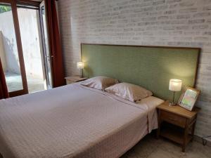 a bedroom with a bed with a green headboard and two lamps at Holiday apartment in Lumio with swimming pool in Lumio