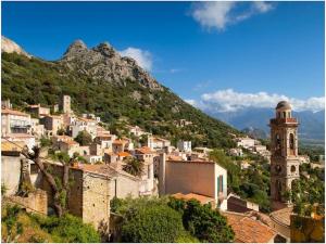 a town on a hill with a clock tower at Holiday apartment in Lumio with swimming pool in Lumio