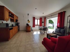a kitchen and living room with red curtains and a couch at Holiday apartment in Lumio with swimming pool in Lumio +28 photos