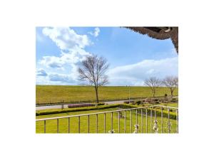 a view of a field with a fence and a tree at Dream holiday under a thatched roof in Brunsbüttel