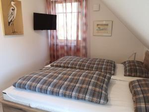 Un dormitorio con una cama con una manta a cuadros. en Hannes' thatched house on Rügen, en Mellnitz