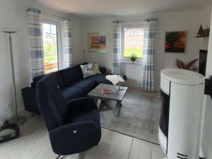 Una sala de estar con un sofá azul y una mesa. en Hannes' thatched house on Rügen, en Mellnitz
