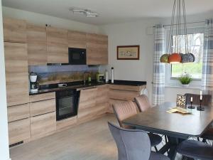 Una cocina con una mesa y un comedor. en Hannes' thatched house on Rügen, en Mellnitz