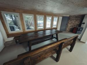 una panca in legno in una stanza con finestre di House Lisbeth - Apartment Lina a Vesser