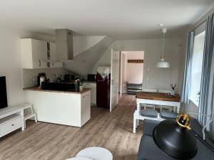 a kitchen and living room with a couch and a table at The Linnebargs, House 2 in Bisdorf