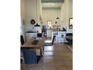 een keuken met een houten tafel en stoelen bij Holiday home aison Le Barret in Sallelles