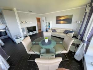 ein Wohnzimmer mit einer Couch und einem Tisch und Stühlen in der Unterkunft Holiday apartment with 1 bedroom in Maasholm