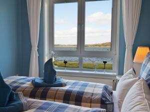 ein Schlafzimmer mit einem Bett mit einem großen Fenster in der Unterkunft Holiday apartment with 1 bedroom in Maasholm