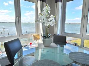 einen Glastisch mit Stühlen und eine Vase mit Blumen in der Unterkunft Holiday apartment with 1 bedroom in Maasholm