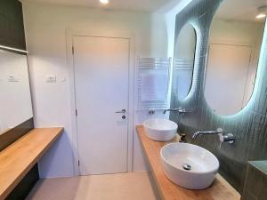 un bagno con due lavandini e un grande specchio di Villa Kinkeli Villa Kinkeli a Cere Altre 32 foto