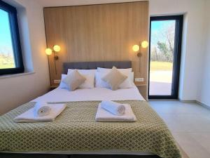 una camera da letto con un letto grande con asciugamani sopra di Villa Kinkeli Villa Kinkeli a Cere