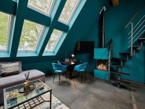 Romantic Uproom في Albachten: غرفة معيشة بجدران زرقاء وطاولة ومدفأة
