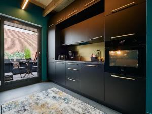 Romantic Uproom في Albachten: مطبخ بخزائن سوداء ونافذة وطاولة