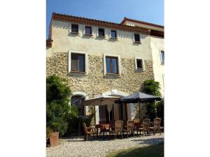 a group of tables and umbrellas in front of a building at Syrah - Domaine La Flotte in Chalabre