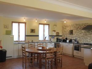 a large kitchen with a wooden table and chairs at Syrah - Domaine La Flotte in Chalabre
