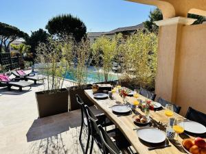 een houten tafel met eten op een patio bij Maison Laurier Rose in Plan-de-la-Tour