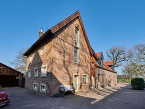 Holiday rooms with 0 bedrooms في Albachten: مبنى من الطوب مع سيارة متوقفة أمامه