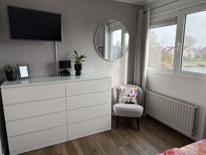 a bedroom with a dresser with a mirror and a chair at Holiday home in Makkum with swimming pool in Holle Poarte +31 photos