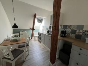 eine Küche mit einem Tisch und Stühlen sowie einem Tisch und einer Theke in der Unterkunft Holiday apartment in Herzhorn with barbecue in Kollmar