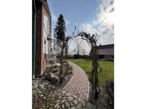 ein gemauerter Gehweg neben einem Gebäude mit Bäumen in der Unterkunft Holiday apartment in Herzhorn with barbecue in Kollmar