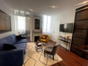 ein Wohnzimmer mit einem blauen Sofa und Stühlen in der Unterkunft Le Cannet apartmment for 4 Guests in Tanneron