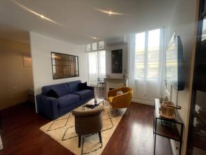 ein Wohnzimmer mit einem blauen Sofa und Stühlen in der Unterkunft Le Cannet apartmment for 4 Guests in Tanneron