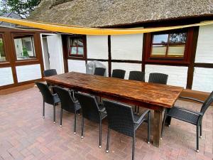 Una mesa y sillas de madera en un patio. en Cabin in Quickborn with swimming pool, en Quickborn