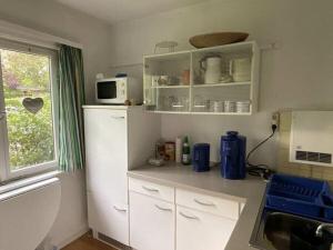 een keuken met witte kasten en een witte koelkast bij Holiday home with 1 bedroom in Tätendorf-Eppensen +5 foto's