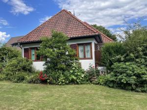 een klein huis met een groene tuin ervoor bij Holiday home with 1 bedroom in Tätendorf-Eppensen
