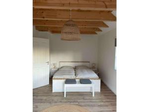 a bedroom with a white bed and a hanging light at The Linnebargs, House 3 in Bisdorf