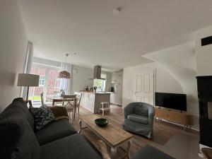 a living room with a couch and a dining room at The Linnebargs, House 3 in Bisdorf