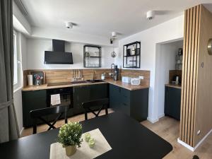 eine Küche mit grünen Schränken und einem schwarzen Tisch in der Unterkunft Nature Love Sauerland in Balve