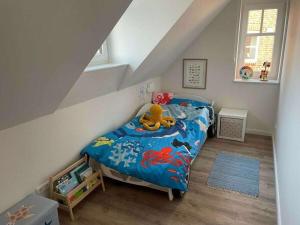a bedroom with a bed with a stuffed animal on it at The Linnebargs, House 4 in Bisdorf