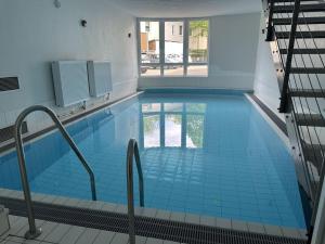 una grande piscina con piastrelle blu in un edificio di Villa Marin, Apartment 6 a Zinnowitz