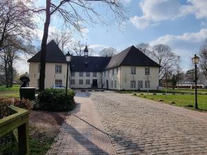 博克霍尔恩Holiday apartment on the primeval forest road的一条鹅卵石街道上的白色大房子