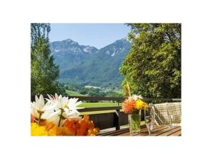 Holiday apartment with 1 bedroom في Kirchberg: مزهرية من الزهور على طاولة مع جبال في الخلفية