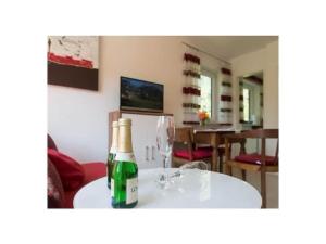 Holiday apartment with 1 bedroom في Kirchberg: زجاجة شمبانيا موضوعة على طاولة مع كأس نبيذ