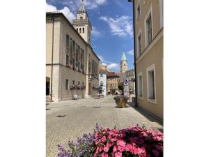 Holiday apartment with 1 bedroom في Kirchberg: شارع في المدينة مزين بالزهور وبرج الساعة +4 صور